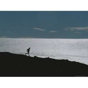 Silhouette of Man Jogging Past a Bare Glacier Below Patriot Hills 