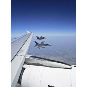  Two F 16 Jet Fighters Fly Alongside the Wing of an Airbus 