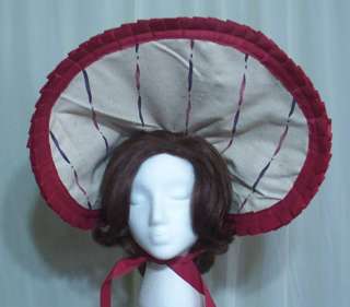   poke bonnet trimmed with burgundy ribbon. It is fully lined. The brim