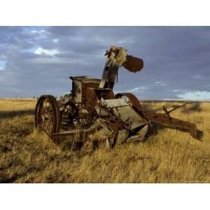 Discarded Antique Farm Harvester Machinery Rusting in a Field at Dawn 